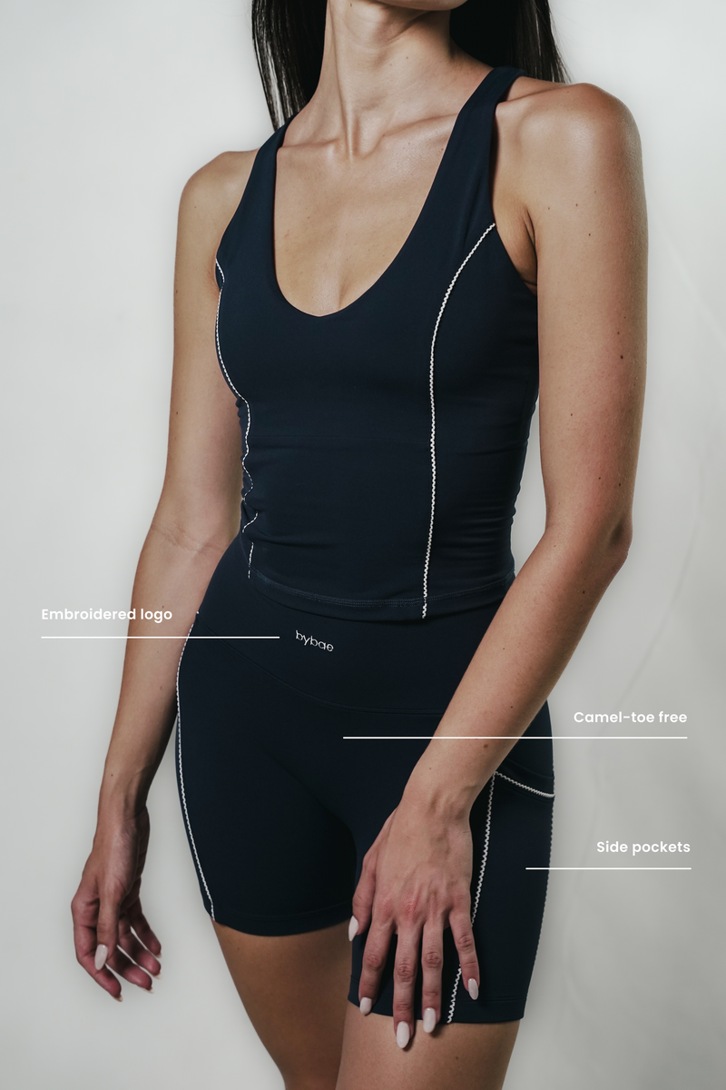 Model wearing Vintage Blue Original Shorts with lace trim and embroidered logo, showcasing a flattering fit and comfortable stretch fabric for active and casual wear.